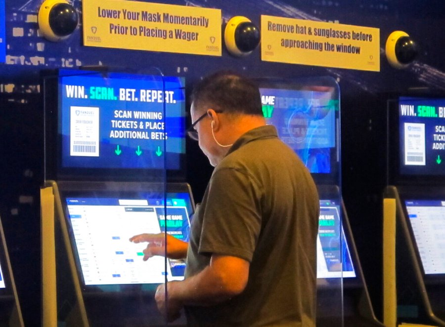 A gambler places a bet at the FanDuel sportsbook in East Rutherford N.J. on Aug. 30, 2021. (AP Photo/Wayne Parry)