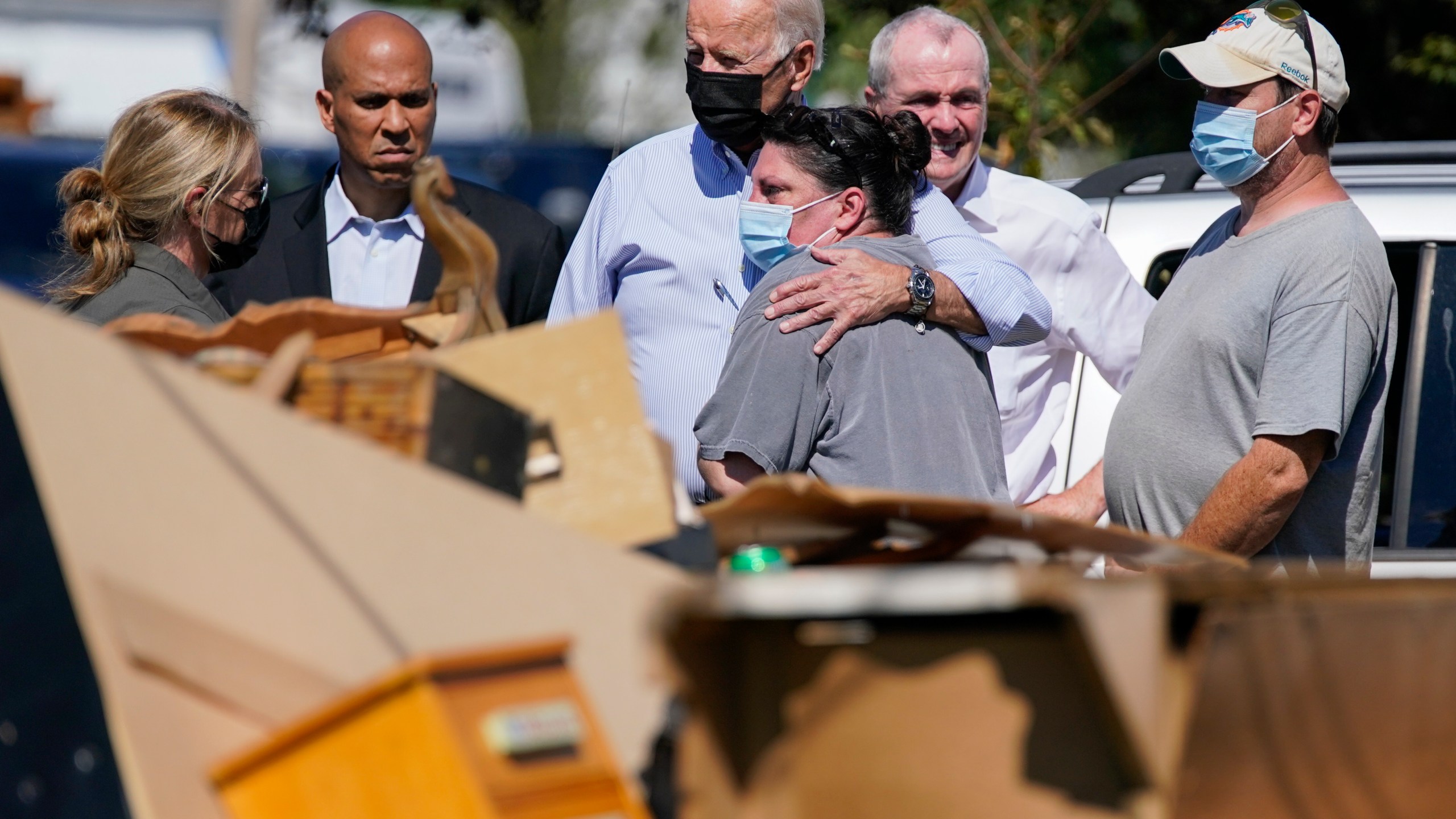 President Joe Biden hugs a person as he tours a neighborhood impacted by Hurricane Ida in Manville, N.J. on Sept. 7, 2021. Sen. Cory Booker, D-N.J., second from left, and New Jersey Gov. Phil Murphy, second from right, look on. (Evan Vucci/Associated Press