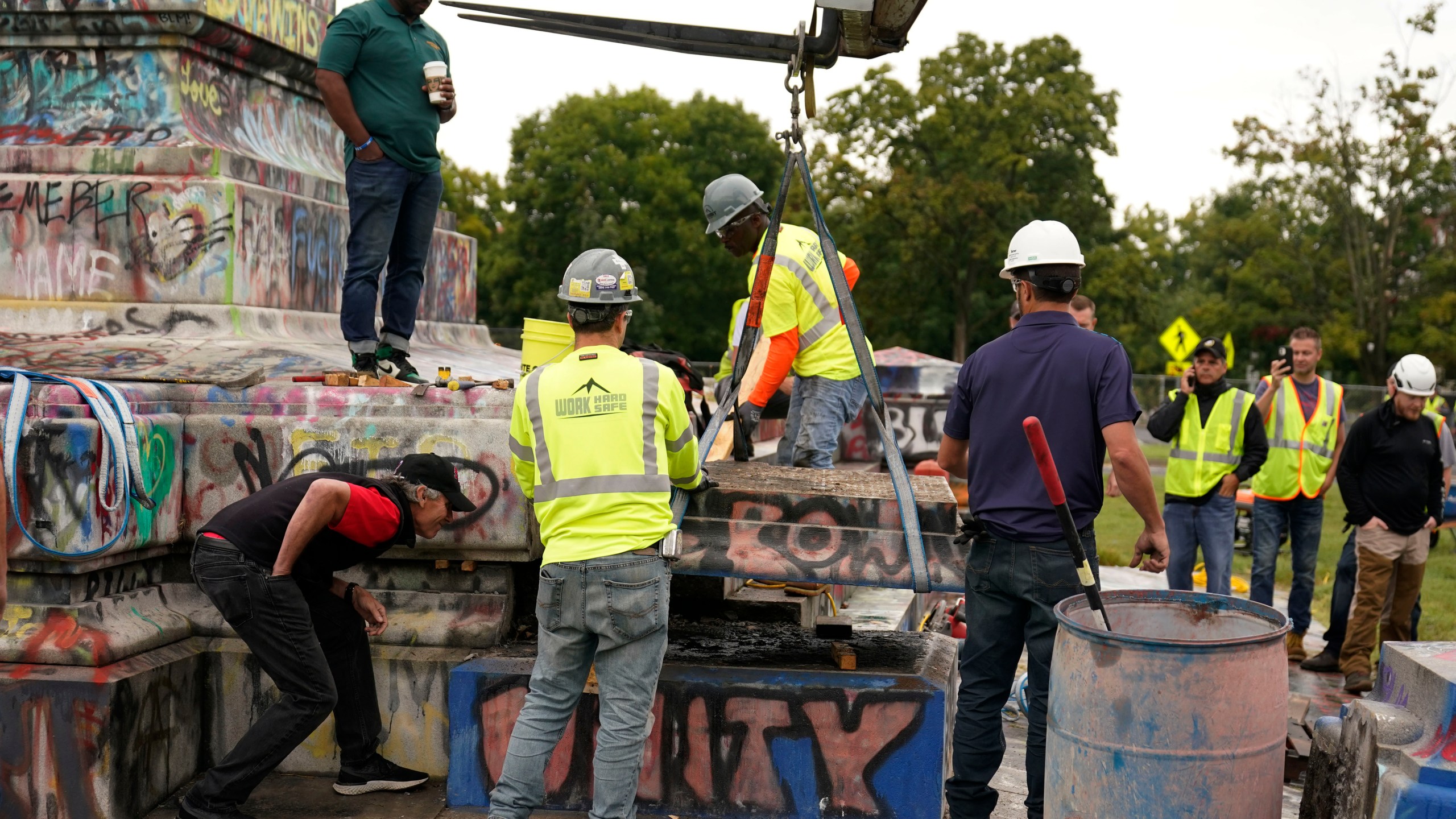 Crews move a section of the base as they attempt to locate a time capsule said to be buried in the base of the statue of on Monument Avenue in Richmond, Va., Thursday, Sept. 9, 2021. The statue was removed from the pedestal on Wednesday. (AP Photo/Steve Helber)