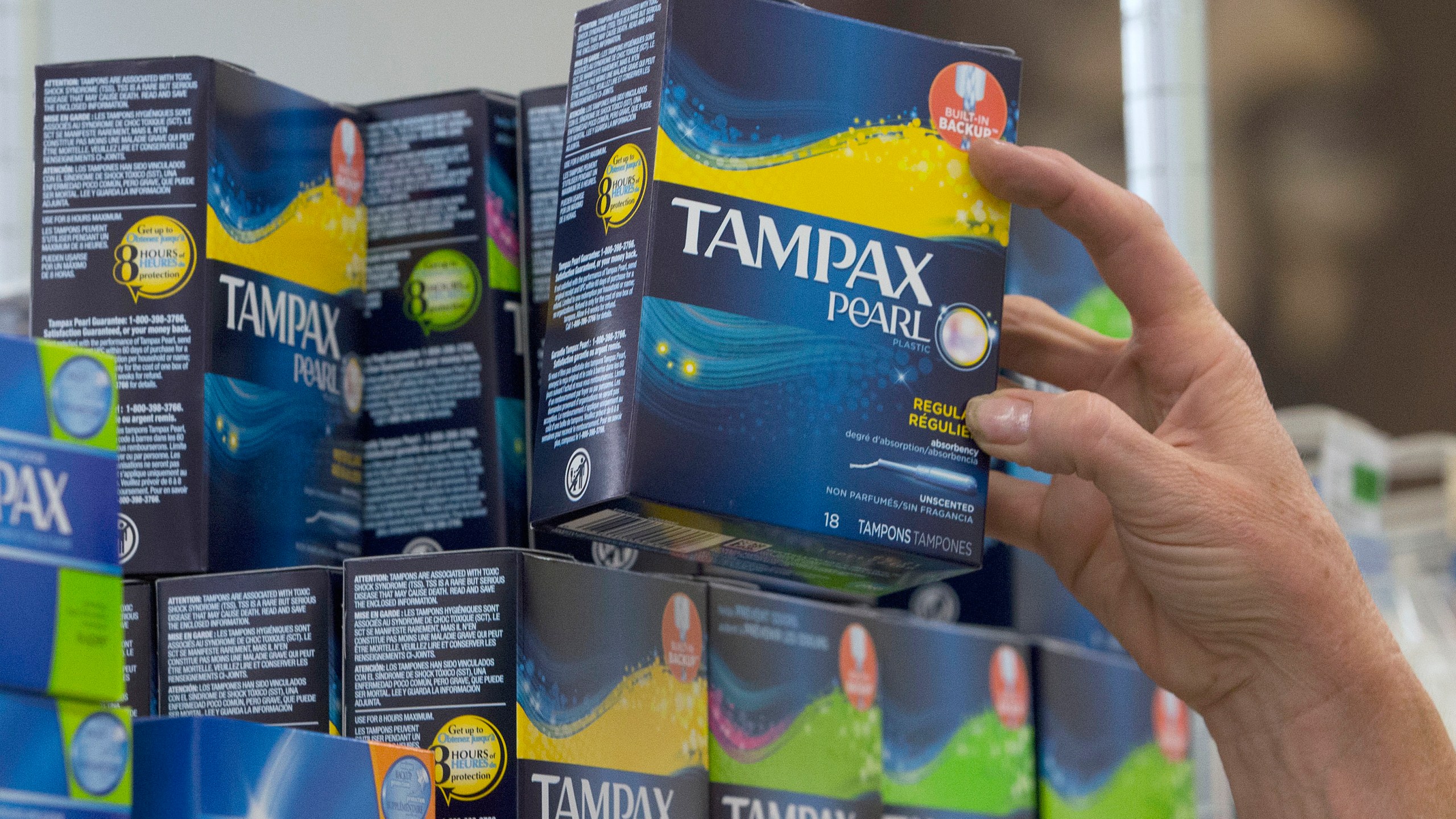 In this June 22, 2016, file photo, Tammy Compton restocks tampons at Compton's Market, in Sacramento, Calif. California public schools and colleges would have to stock their restrooms with free menstrual products under legislation sent to Gov. Gavin Newsom on Thursday, Sept. 9, 2021. The bill by Democratic Assemblywoman Cristina Garcia builds on her 2017 law requiring low-income schools in disadvantaged areas to provide students with free menstrual products. (AP Photo/Rich Pedroncelli, File)