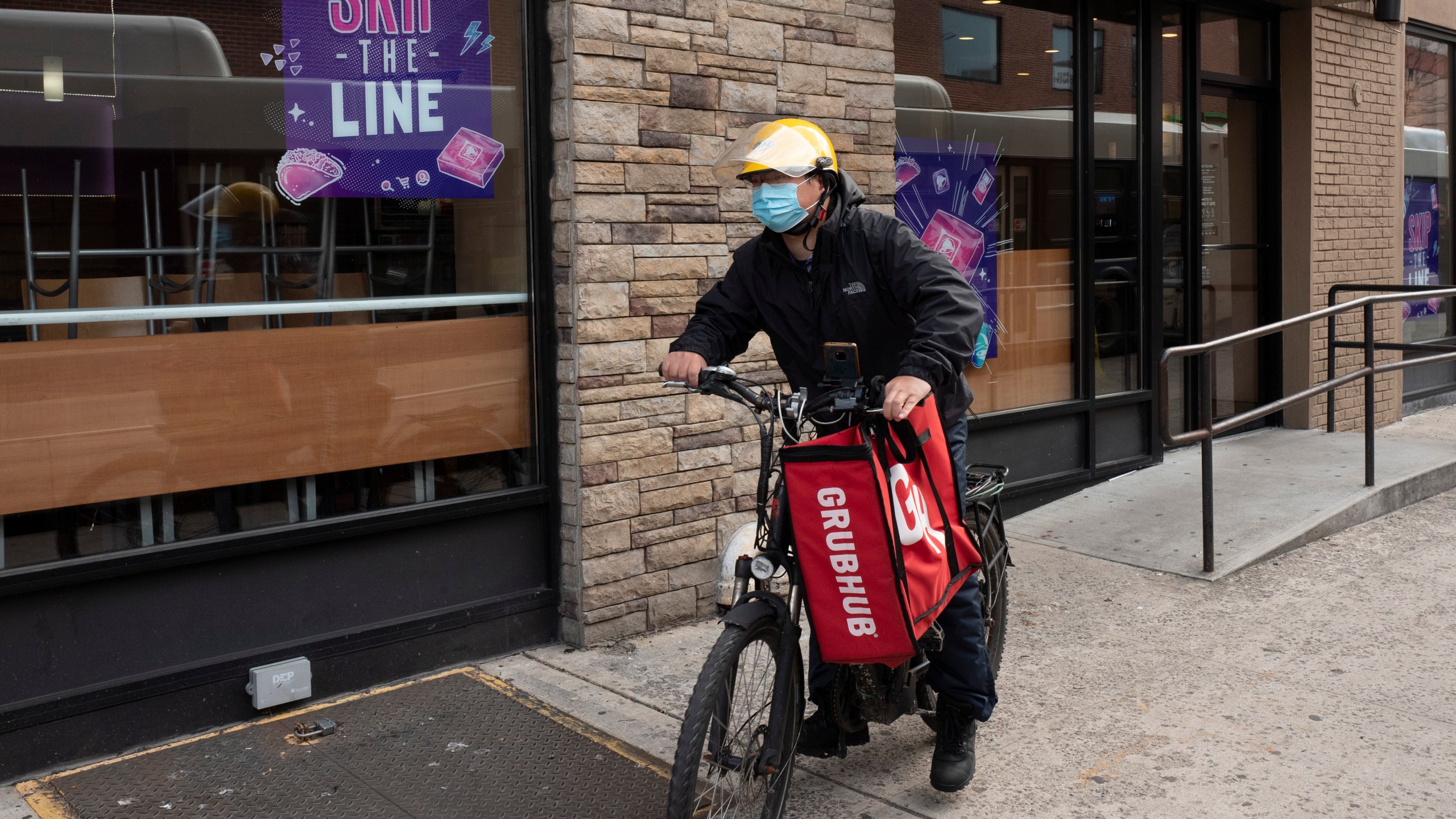 In this April 21, 2021, file photo, a delivery man bikes with a food bag from Grubhub in New York. (AP Photo/Mark Lennihan, File)