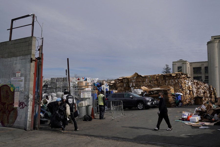 In this Feb. 18, 2021, file photo, people walk inside a recycling location in Oakland, Calif. California lawmakers have approved what advocacy groups say are the nation's strongest protections against falsely labeling items as recyclable when they in fact are destined for landfills. (AP Photo/Jeff Chiu, File)