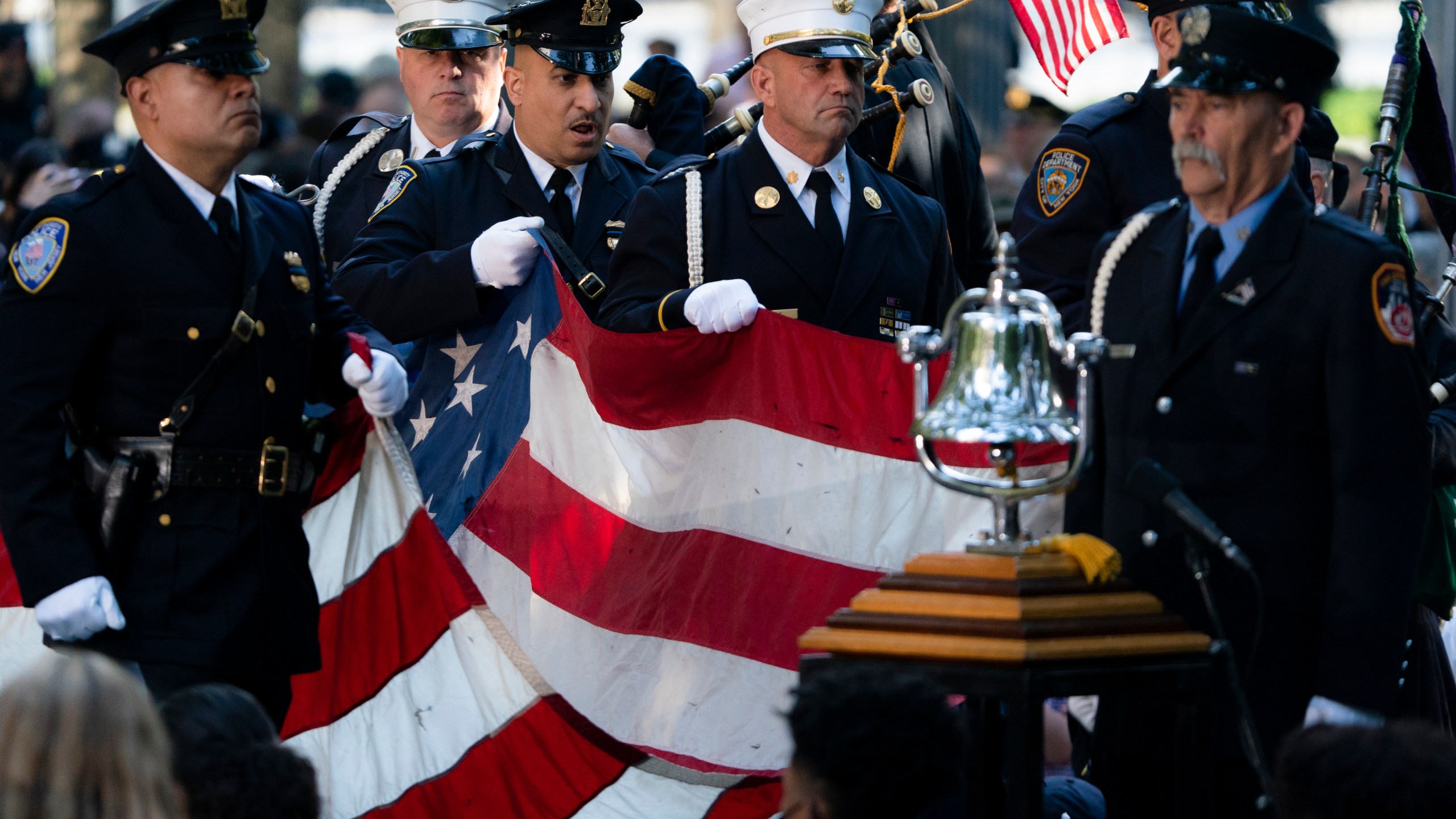 A memorial flag is brought onto the stage during ceremonies to commemorate the 20th anniversary of the Sept. 11 terrorist attacks, Saturday, Sept. 11, 2021, at the National September 11 Memorial & Museum in New York. (AP Photo/John Minchillo)