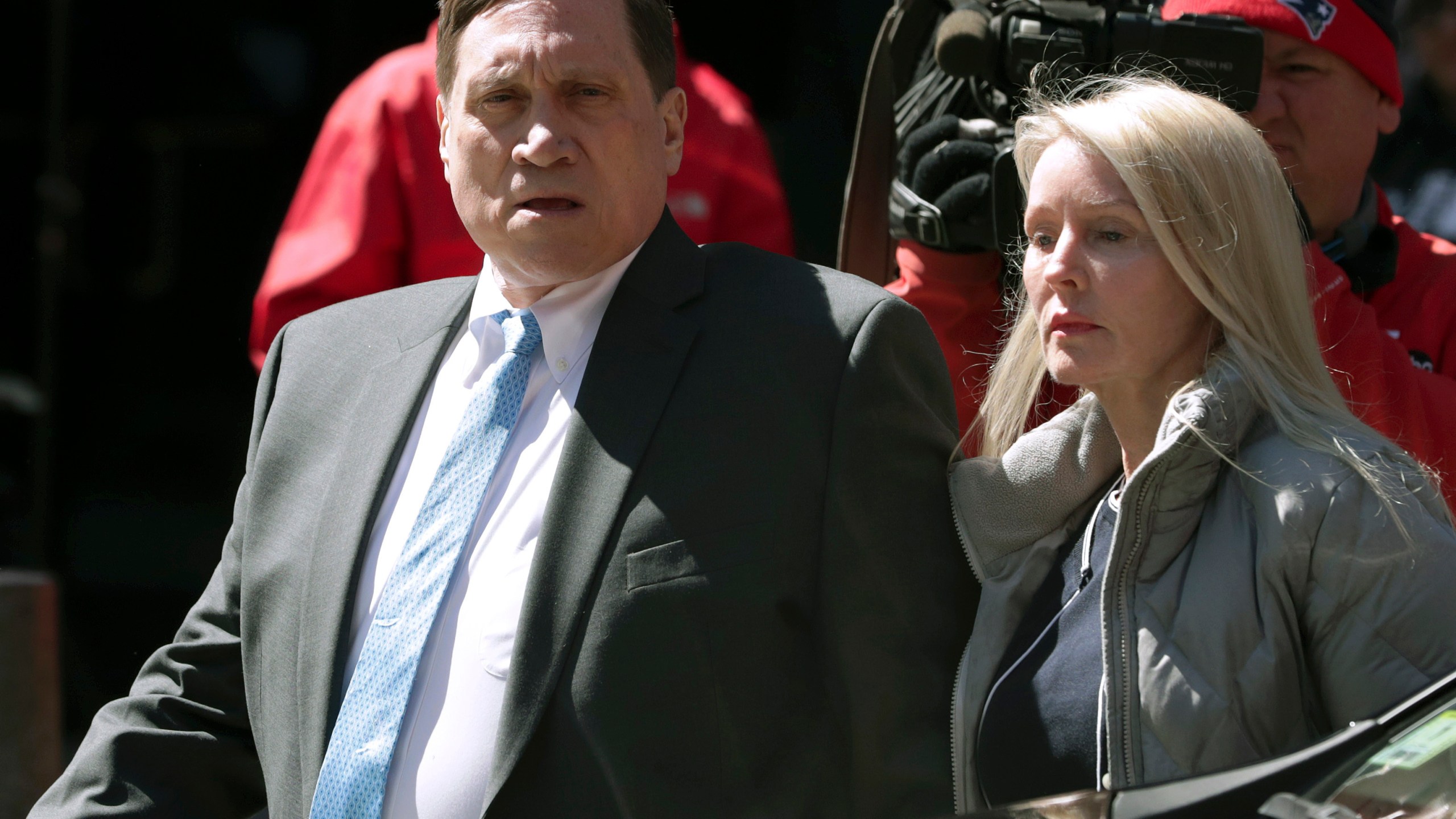 Investor John Wilson, left, arrives at federal court in Boston with his wife Leslie in this Wednesday, April 3, 2019 file photo, to face charges in a nationwide college admissions bribery scandal. The first trial in the college admissions bribery scandal opened Monday, Sept. 13, 2021, with defense attorneys seeking to portray the two parents accused of buying their kids' way into school as victims of deception who believed their payments were legal donations. (AP Photo/Charles Krupa, File)