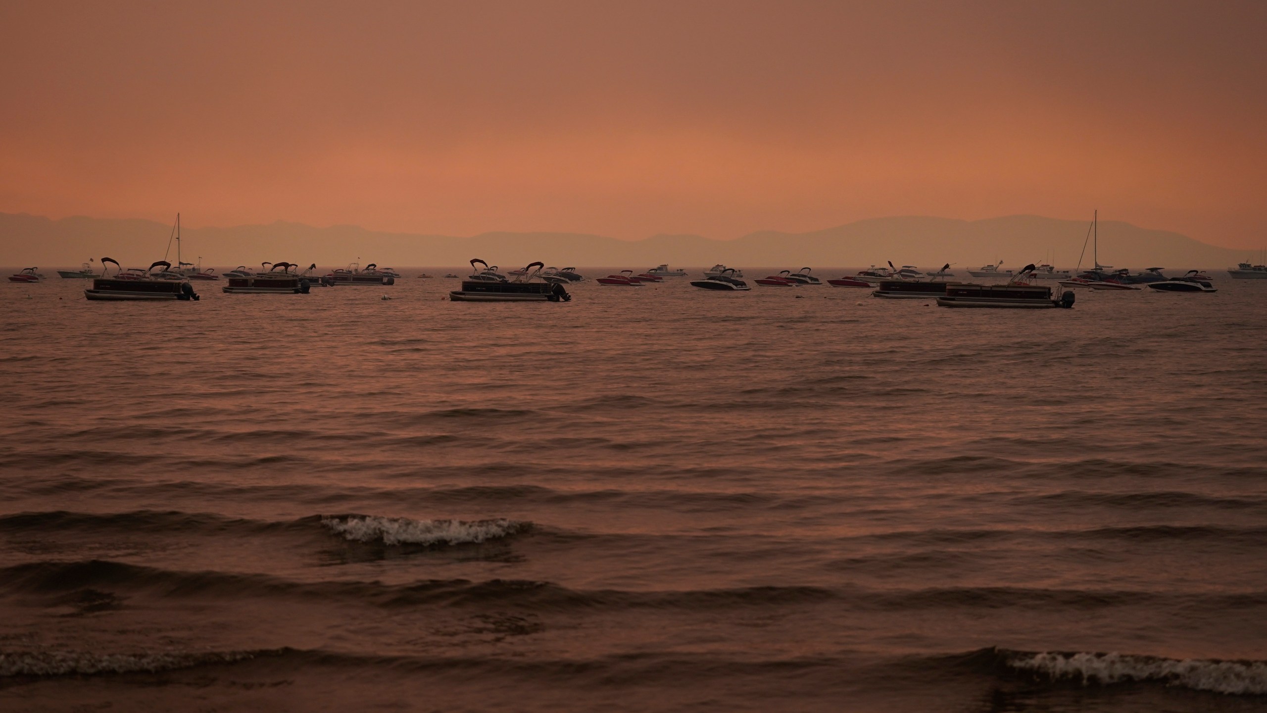 Boats float in the water away from a dock in South Lake Tahoe, Calif., as the Caldor Fire approaches on Aug. 31, 2021. (Jae C. Hong / Associated Press)