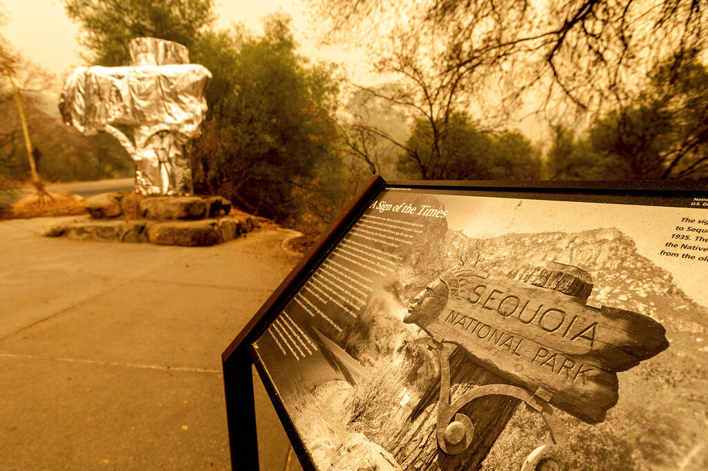 Fire-resistant wrap covers a historic welcome sign as the KNP Complex Fire burns in Sequoia National Park, Calif., on Wednesday, Sept. 15, 2021. (AP Photo/Noah Berger)