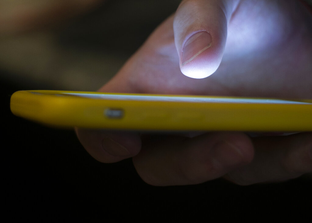 In this Aug. 11, 2019, file photo, a man uses a cellphone in New Orleans. (AP Photo/Jenny Kane, File)