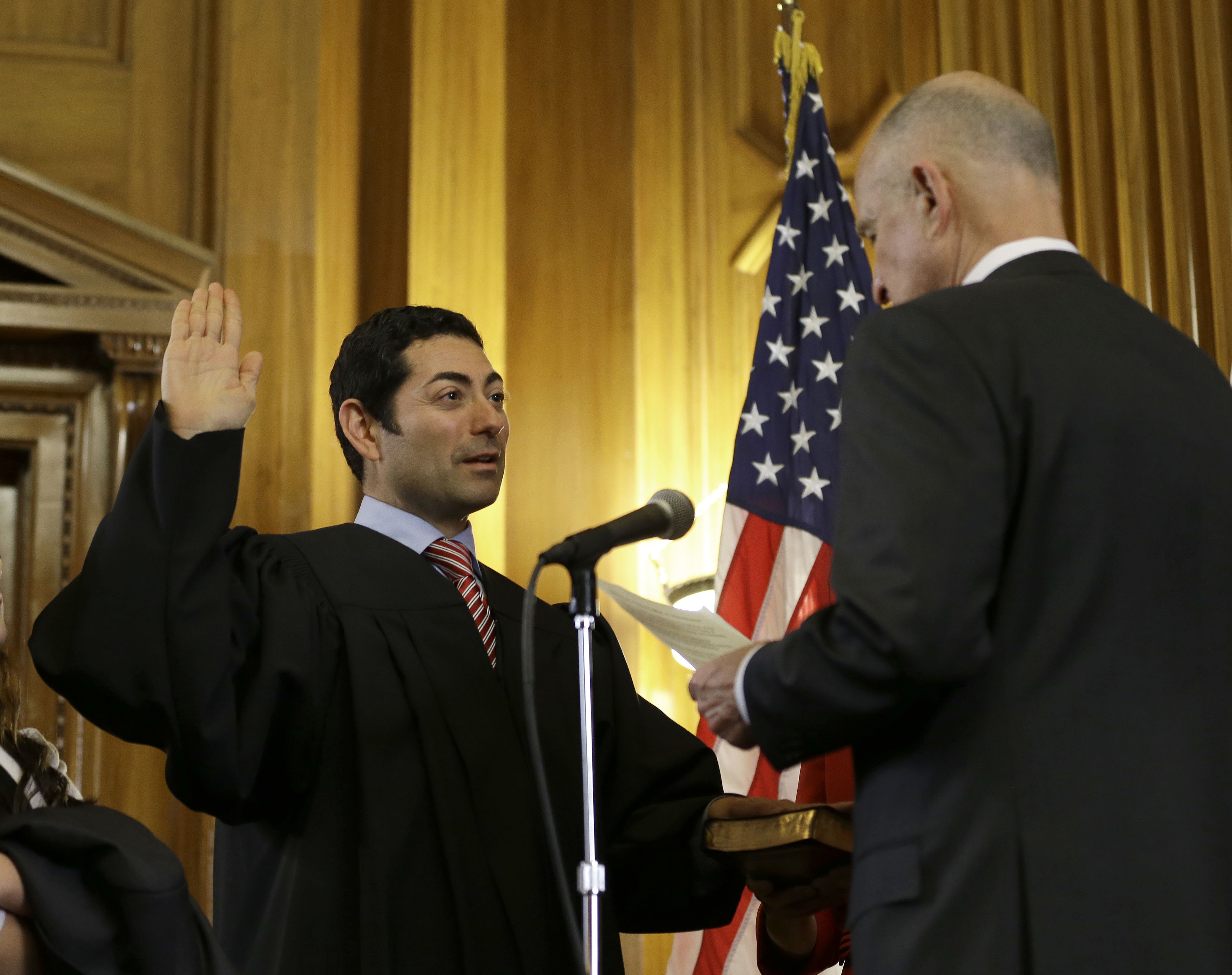 In this Jan. 5, 2015 file photo Mariano-Florentino Cuellar, left, is sworn in as an associate justice to the California Supreme Court by Gov. Jerry Brown during an inauguration ceremony in Sacramento. (Rich Pedroncelli/Associated Press)