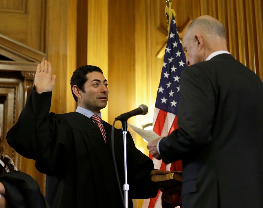 In this Jan. 5, 2015 file photo Mariano-Florentino Cuellar, left, is sworn in as an associate justice to the California Supreme Court by Gov. Jerry Brown during an inauguration ceremony in Sacramento. (Rich Pedroncelli/Associated Press)