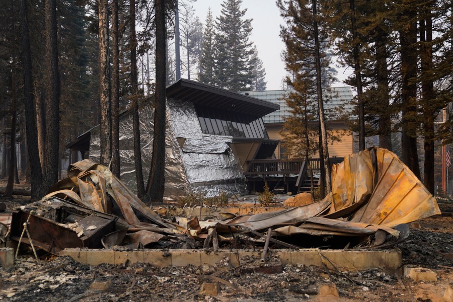 In this Sept. 2, 2021 file photo a cabin partially covered in fire-resistant material stands behind a property destroyed in the Caldor Fire in Twin Bridges, Calif. (AP Photo/Jae C. Hong,File)