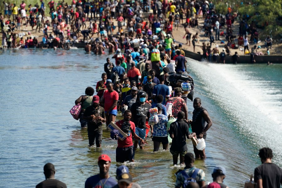 Haitian migrants use a dam to cross to and from the United States from Mexico on Sept. 17, 2021, in Del Rio, Texas. (Eric Gay / Associated Press)