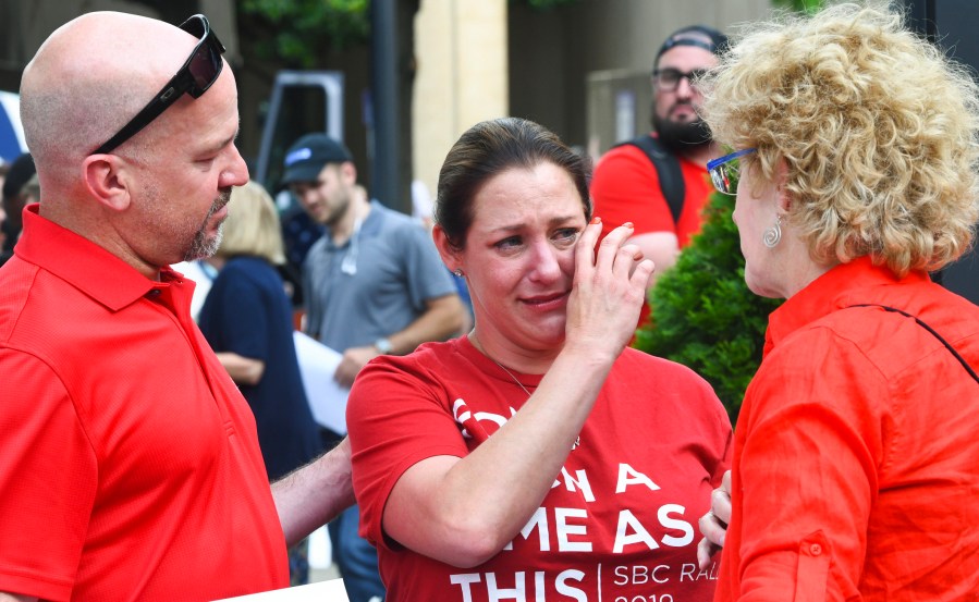 In this Tuesday, June 11, 2019 file photo, Jules Woodson, center, of Colorado Springs, Colo., is comforted by her boyfriend Ben Smith, left, and Christa Brown while demonstrating outside the Southern Baptist Convention's annual meeting in Birmingham, Ala. (AP Photo/Julie Bennett, File)