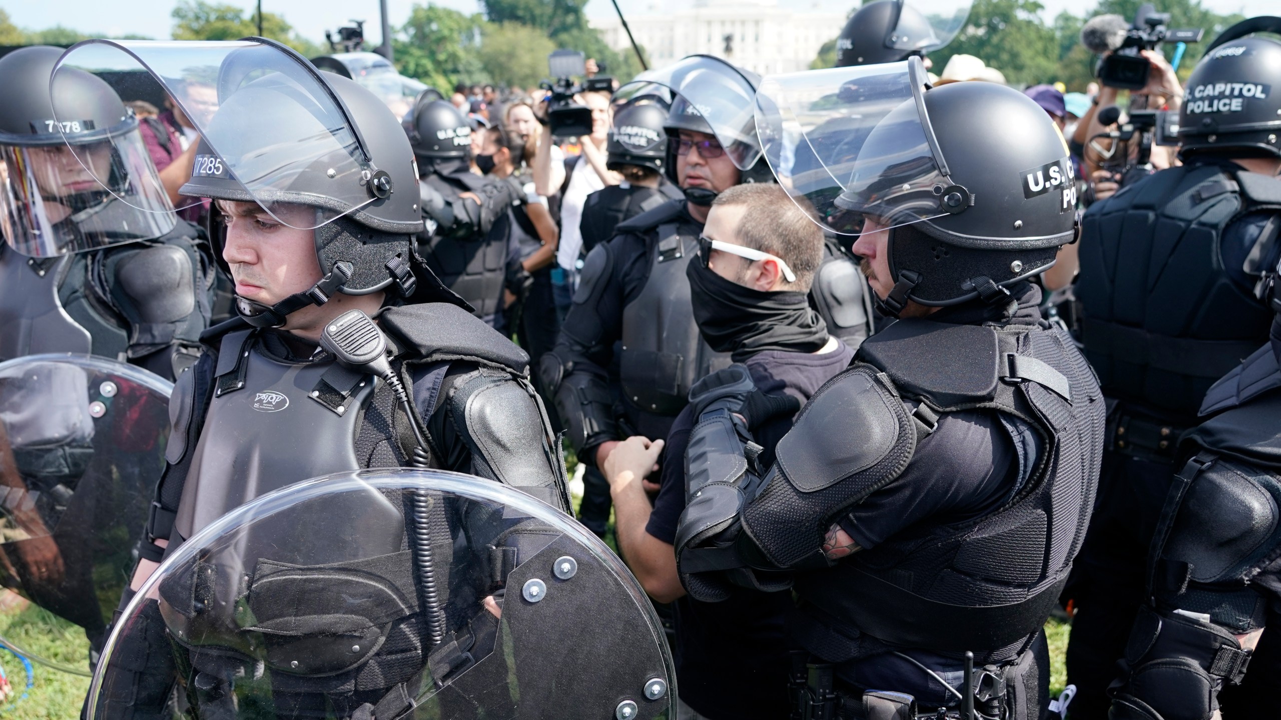 Police circle a man, center with glasses, during a rally near the U.S. Capitol in Washington, Saturday, Sept. 18, 2021. The rally was planned by allies of former President Donald Trump and aimed at supporting the so-called "political prisoners" of the Jan. 6 insurrection at the U.S. Capitol. (AP Photo/Gemunu Amarasinghe)