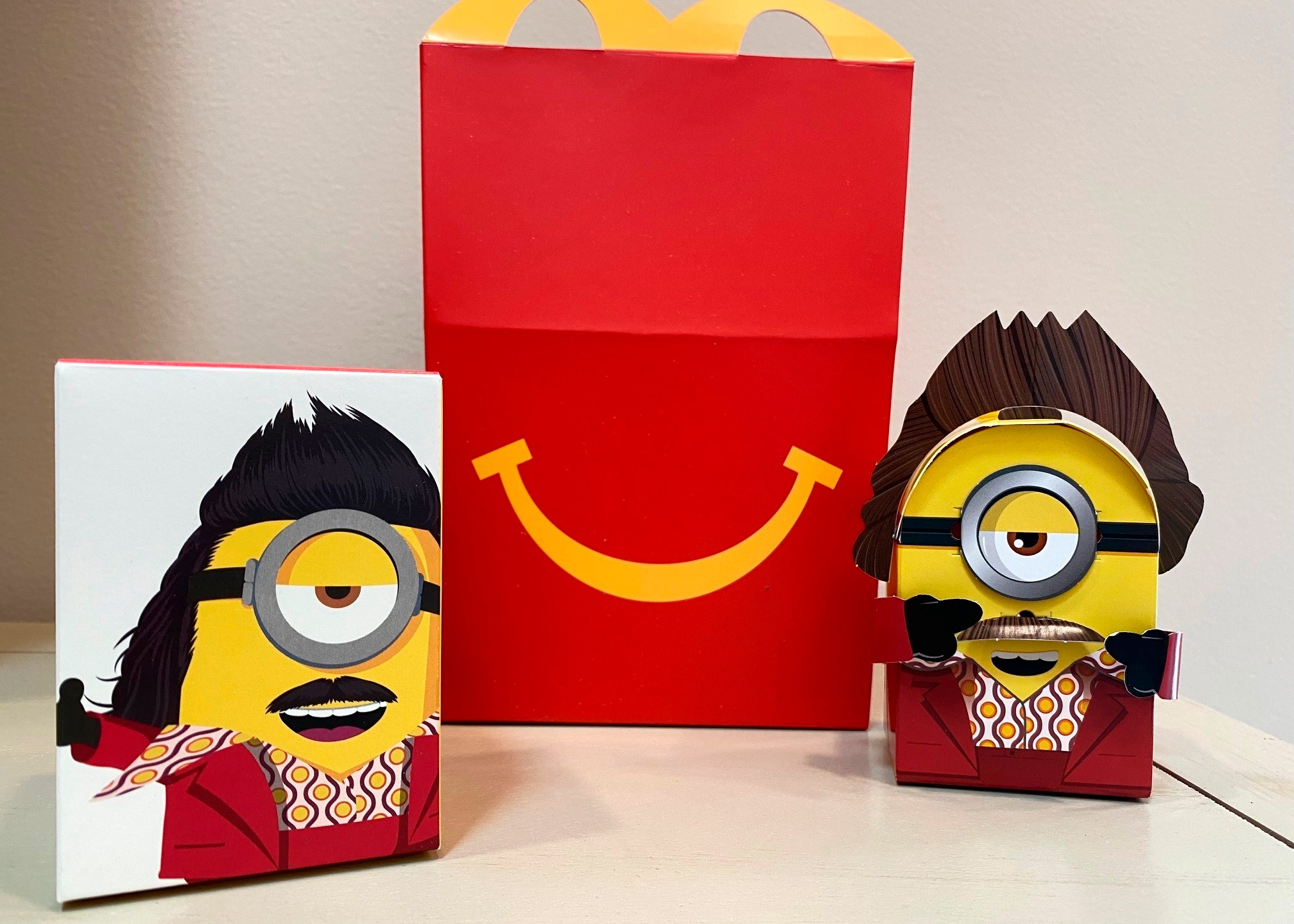 A cardboard McDonald’s Happy Meal toy is shown with a Happy Meal box on Sept. 20, 2021. McDonald’s plans to “drastically” reduce the plastic in its Happy Meal toys worldwide by 2025. The burger giant said Tuesday, Sept. 21 it’s working with toy companies to develop new ideas, such as three-dimensional cardboard superheroes kids can build or board games with plant-based or recycled game pieces. (AP Photo/Dee-Ann Durbin)