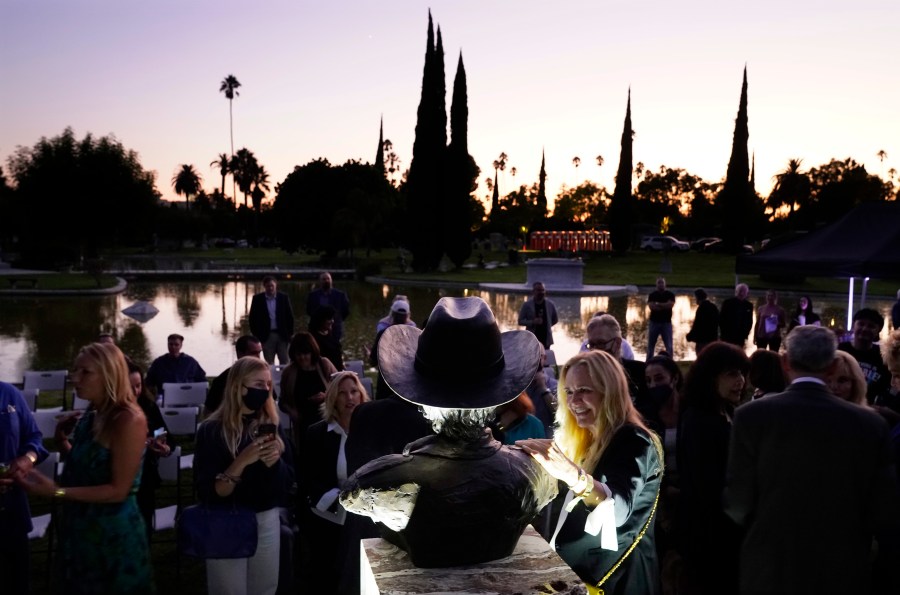 Guests gather around a newly unveiled memorial sculpture of the late actor Burt Reynolds following a ceremony at Hollywood Forever Cemetery on Sept. 20, 2021. (AP Photo/Chris Pizzello)