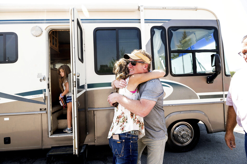 Woody Faircloth hugs Sheri Roen as her family donates their motorhome to EmergencyRV.org on Sunday, Sept. 5, 2021, in Sierra County, Calif. (AP Photo/Noah Berger)