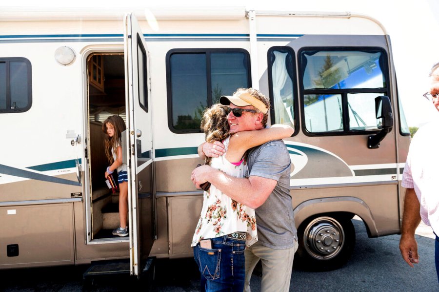 Woody Faircloth hugs Sheri Roen as her family donates their motorhome to EmergencyRV.org on Sunday, Sept. 5, 2021, in Sierra County, Calif. (AP Photo/Noah Berger)