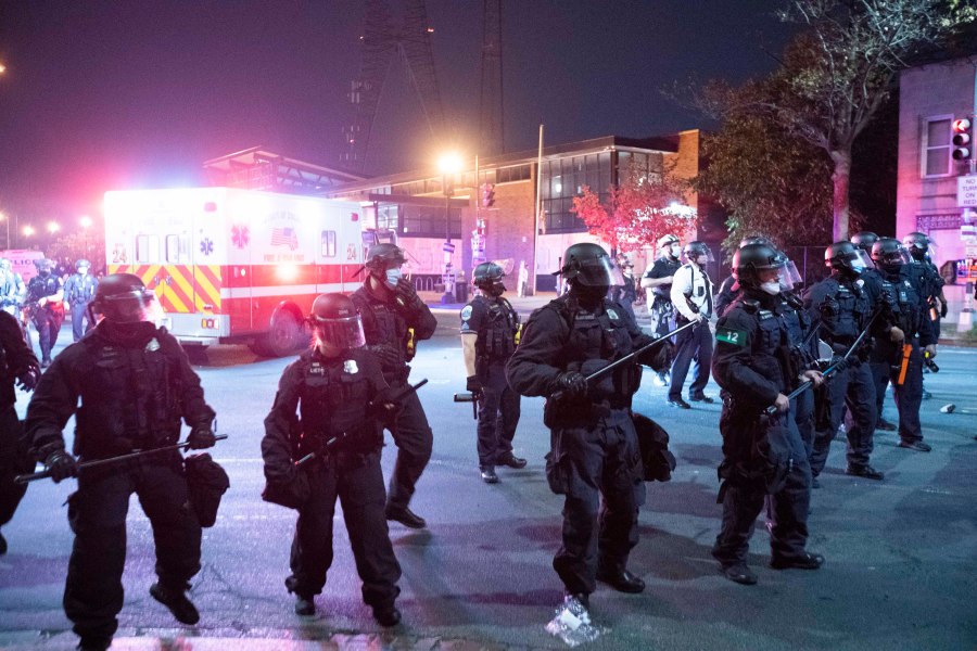 In this Oct. 28, 2020, file photo Washington Metropolitan Police Department police officers push back demonstrators outside of the fourth district police station in Washington. An officer in the nation’s capital has been indicted on a murder charge for his role in a fatal vehicle accident during a police chase that has sparked two days of protests and clashes. Federal prosecutors announced Friday, Sept. 24, 2021, that Terrence Sutton, 37, was indicted on second-degree murder, conspiracy and obstruction of justice charges in connection with the death of 20-year-old Karon Hylton-Brown, who died after a pursuit in Washington, D.C. in October 2020. (AP Photo/Jose Luis Magana, File)