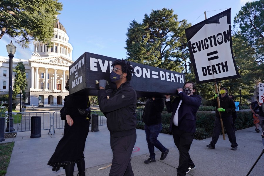 Demonstrators call for passage of rent forgiveness and stronger eviction protections legislation as they carry a mock casket past the Capitol in Sacramento on Jan. 25, 2021. (Rich Pedroncelli / Associated Press)