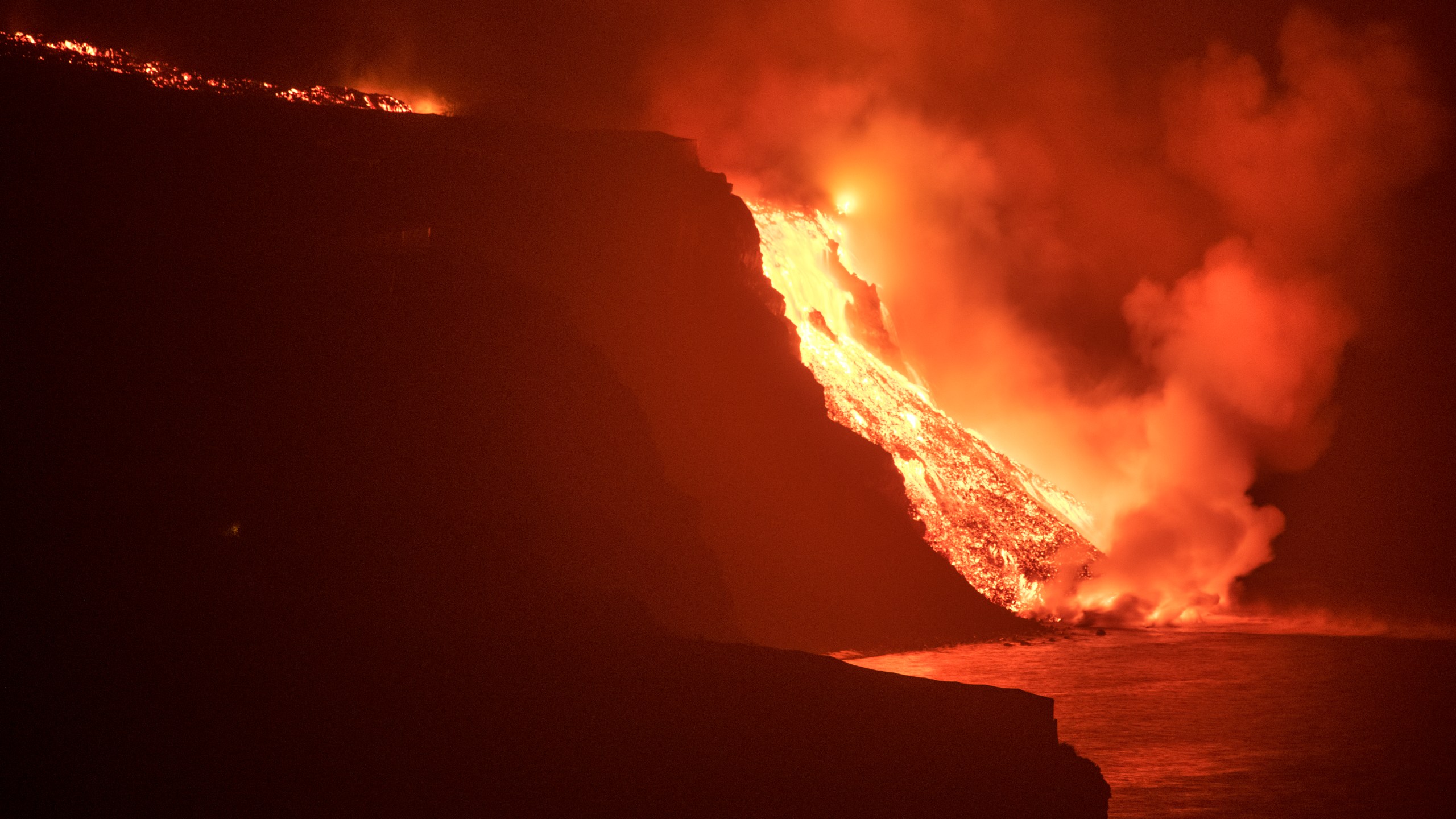 Lava from a volcano reaches the sea on the Canary island of La Palma, Spain in the early hours of Wednesday Sept. 29, 2021. Lava from the new volcano on the Canary Island of La Palma reached the Atlantic ocean last night, at the area known as Los Guirres beach, also known as Playa Nueva (New Beach). (AP Photo/Saul Santos)