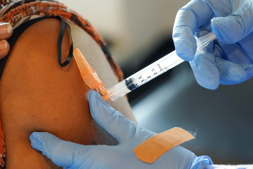 In this Sept. 21, 2021, file photo, Jackson-Hinds Comprehensive Health Center nurse Maggie Bass, right, injects a COVID-19 vaccine into an arm in Jackson, Miss. (AP Photo/Rogelio V. Solis, File)