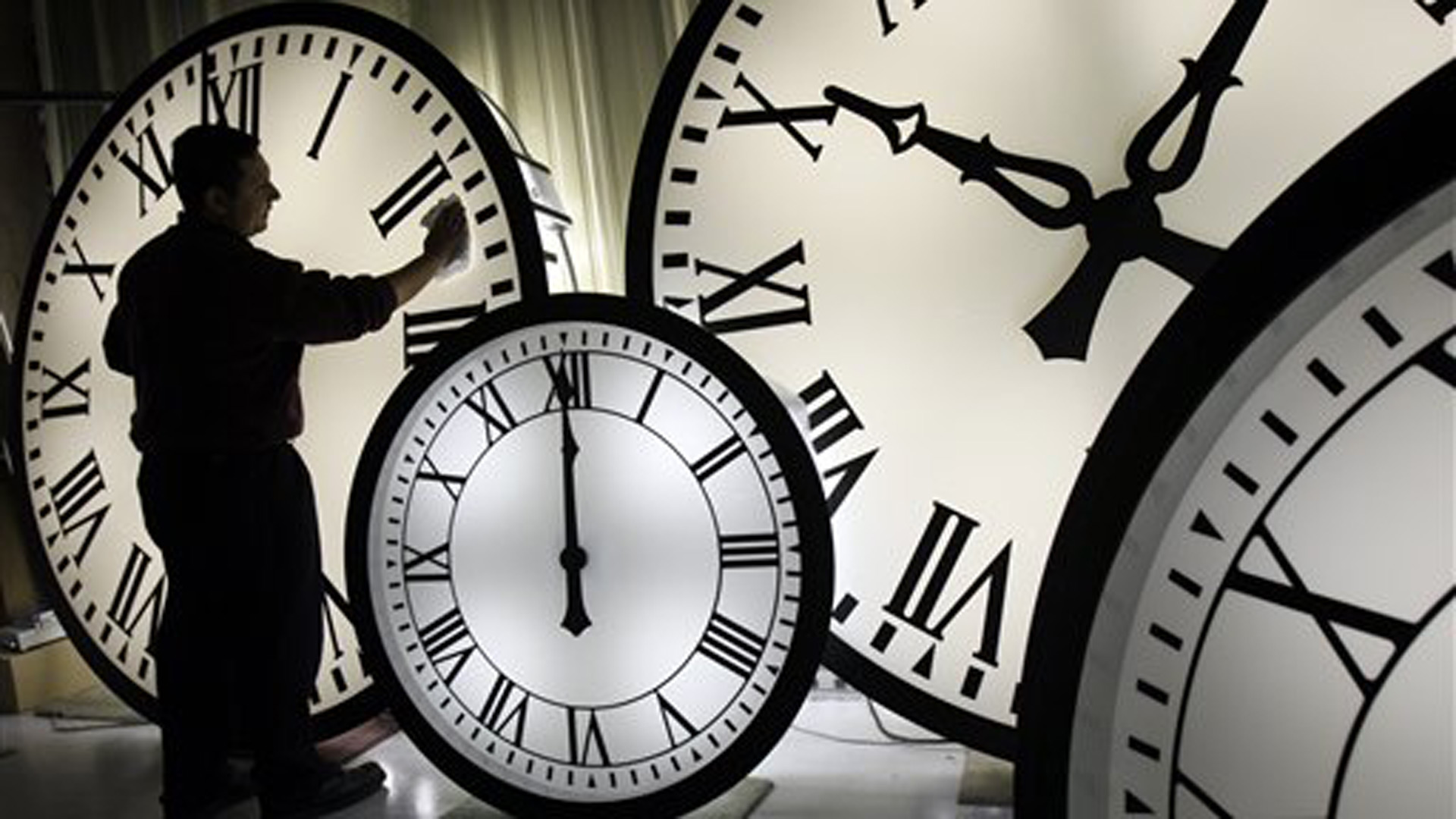 Electric Time Co. employee Walter Rodriguez cleans the face of an 84-inch Wegman clock at the plant in Medfield, Mass. Thursday, Oct. 30, 2008. (AP Photo/Elise Amendola)