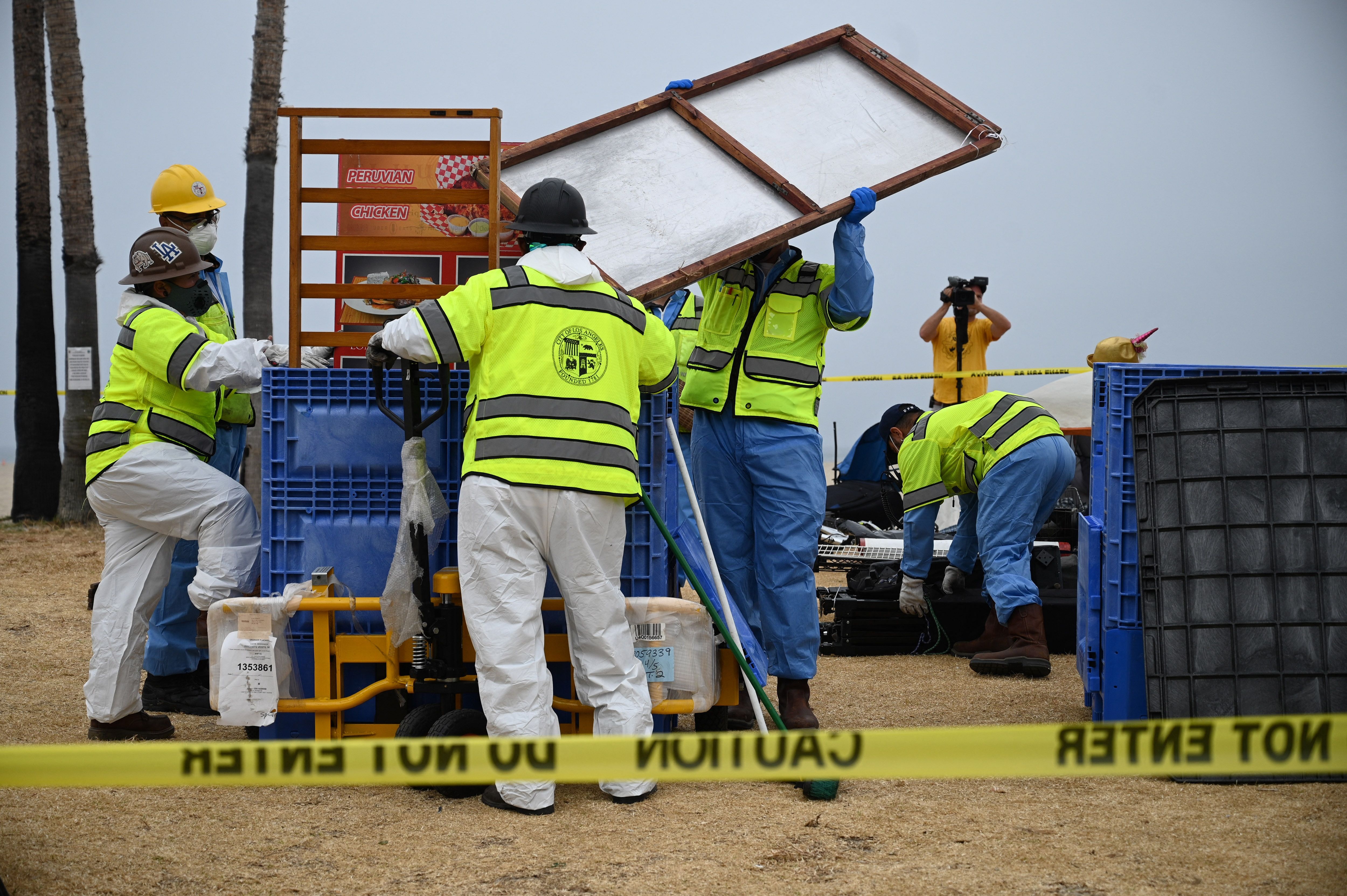 City workers remove homeless encampments at the Venice Beach Boardwalk ahead of the Independence Day holiday weekend, July 2, 2021 in Los Angeles, California. - Authorities are offering unhoused people lining near the beach a path to permanent housing in an effort to clear the popular tourist destination of homeless camps before the July 4th holiday weekend. The number of homeless encampments along the popular tourist destination exploded during the coronavirus pandemic, making it a political flashpoint. (Photo by Robyn Beck / AFP) (Photo by ROBYN BECK/AFP via Getty Images)