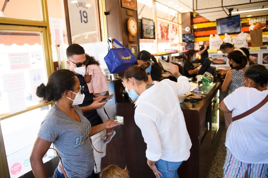 An employee checks a digital vaccine card for proof of COVID-19 vaccination at Langer's Deli in Los Angeles on Aug. 7, 2021. (PATRICK T. FALLON/AFP via Getty Images)