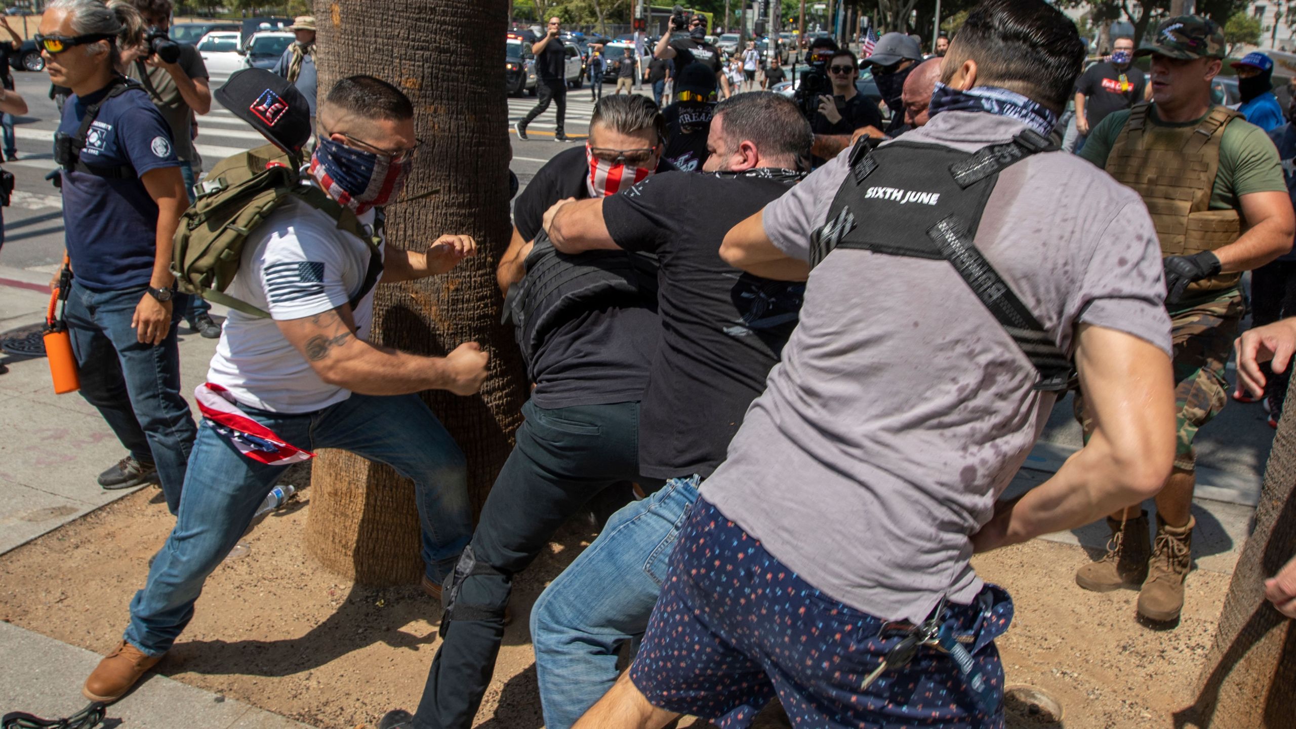 Anti-vaccination protesters beat up a counter protester during an anti-vaccination rally near City Hall following the Los Angeles City Council vote earlier this week to draw up an ordinance to require proof of vaccination to enter many public indoor spaces in Los Angeles, California on August 14, 2021. (DAVID MCNEW/AFP via Getty Images)