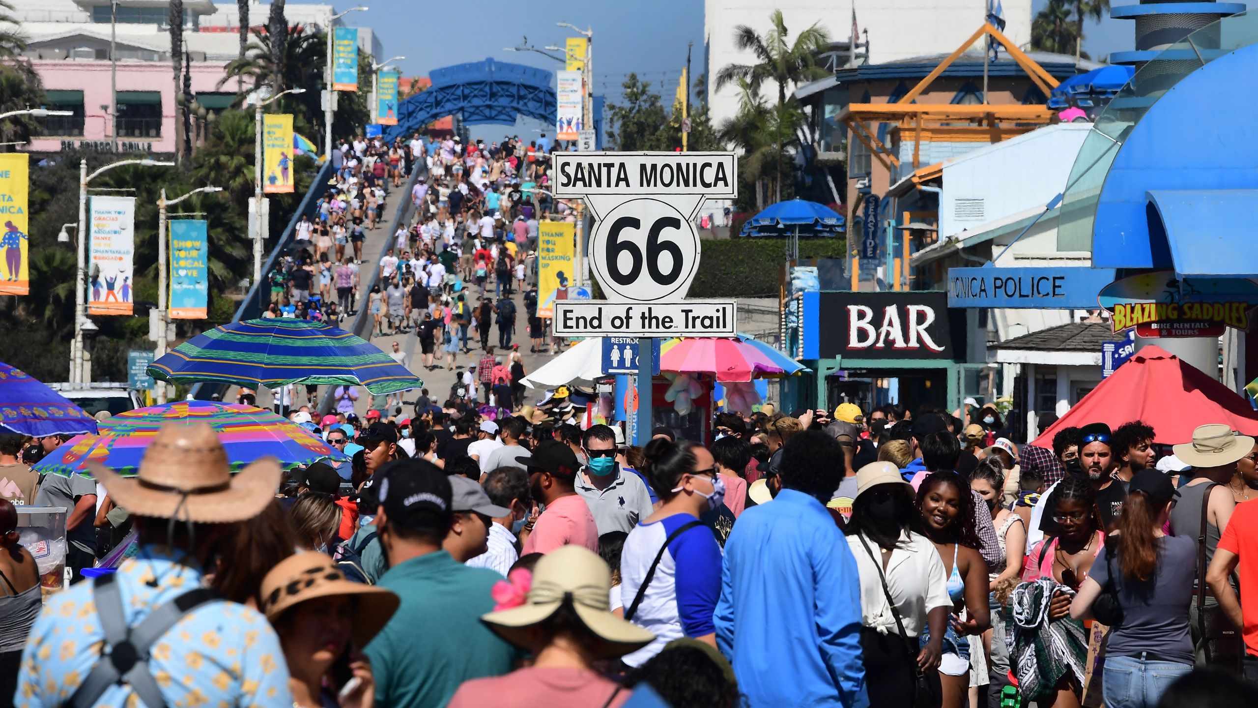 A crowd of people makes it’s way to the end of the trail of Route 66 at Santa Monica Pier as people take to the coastline to beat the heat on Sept. 5, 2021. (FREDERIC J. BROWN/AFP via Getty Images)