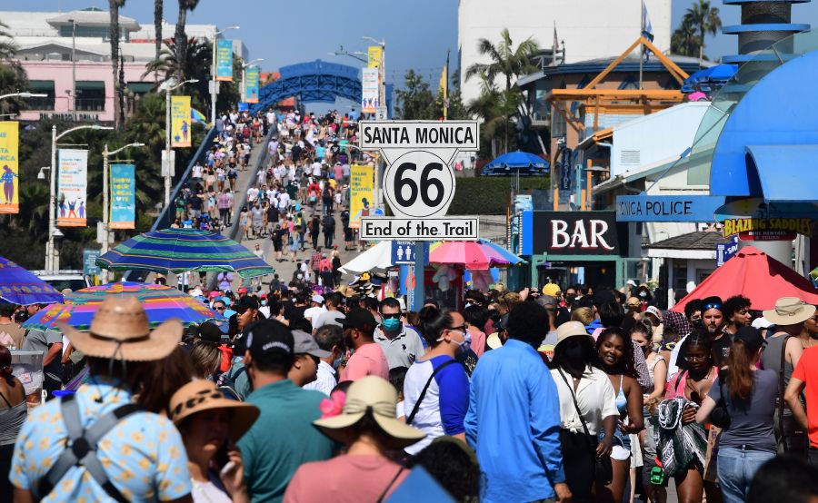 A crowd of people makes it’s way to the end of the trail of Route 66 at Santa Monica Pier as people take to the coastline to beat the heat on Sept. 5, 2021. (FREDERIC J. BROWN/AFP via Getty Images)