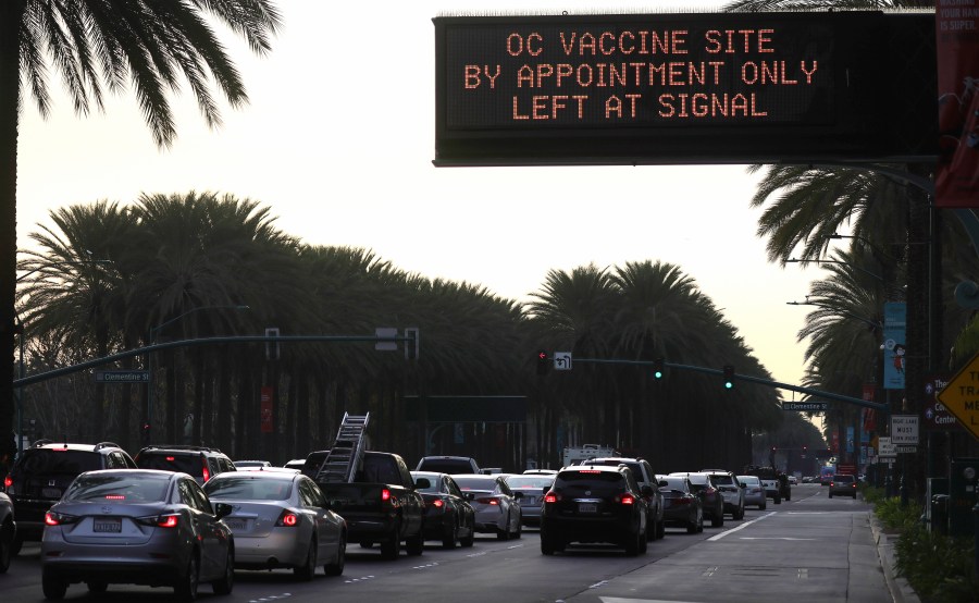 A sign displays directions to a COVID-19 mass vaccination site in a parking lot for Disneyland Resort on Jan. 13, 2021 in Anaheim. (Mario Tama/Getty Images)