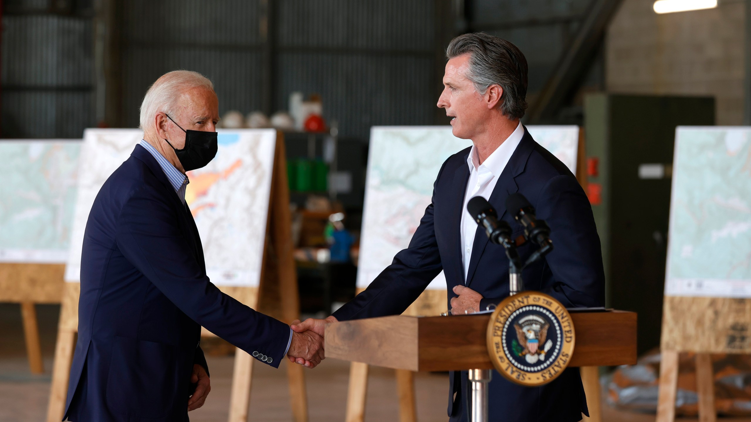 President Joe Biden, left, shakes hands with California Gov. Gavin Newsom as they arrive to deliver remarks to reporters after a helicopter tour of the Caldor Fire, at Mather Airport outside Sacramento on Sept. 13, 2021. (Justin Sullivan / Getty Images)