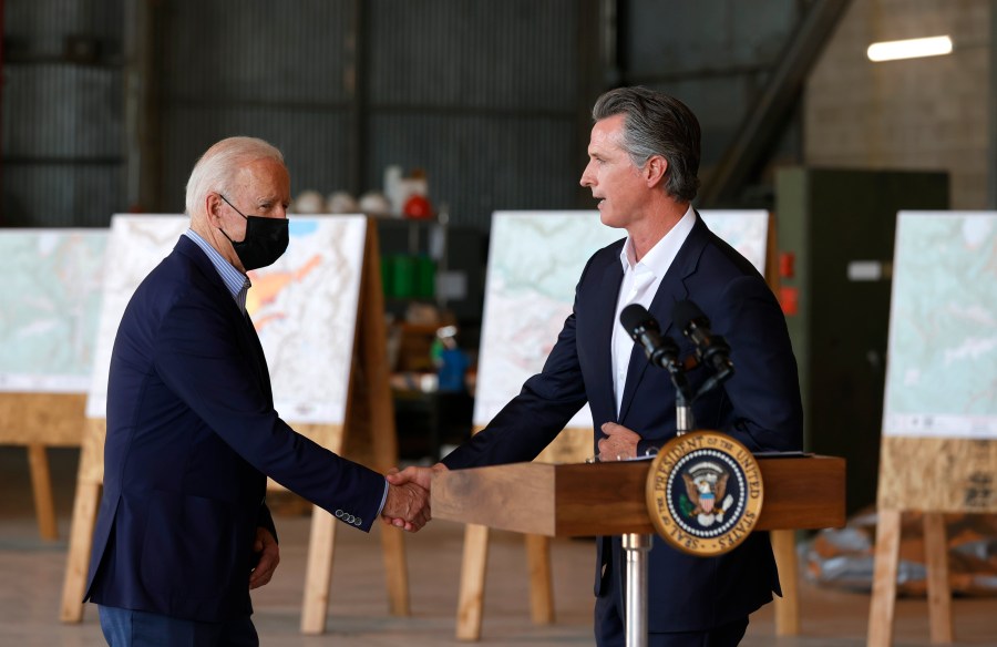 President Joe Biden, left, shakes hands with California Gov. Gavin Newsom as they arrive to deliver remarks to reporters after a helicopter tour of the Caldor Fire, at Mather Airport outside Sacramento on Sept. 13, 2021. (Justin Sullivan / Getty Images)