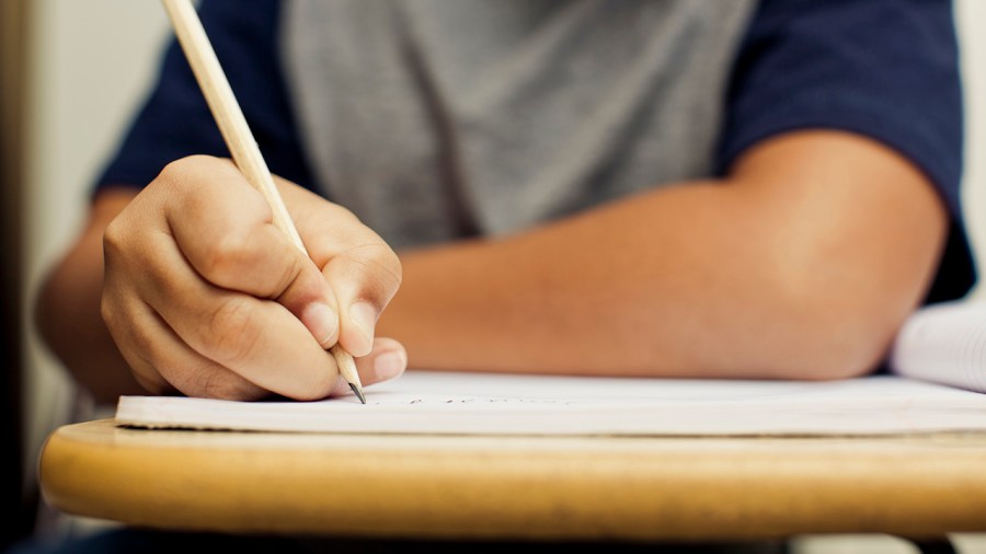 A student writes at a desk in this undated file photo. (Getty Images)