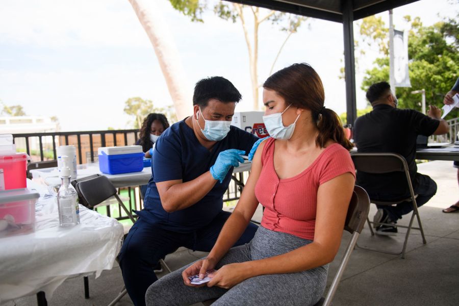 A CSULB student receives a first dose of the Pfizer Covid-19 vaccine during a City of Long Beach Public Health Covid-19 mobile vaccination clinic at the California State University Long Beach (CSULB) campus on Aug. 11, 2021 in Long Beach, California. - Students, staff, and faculty at the California State University (CSU) and University of California (UC) system schools will be required to be fully vaccinated in order to attend in-person classes. All teachers in California will have to be vaccinated against Covid-19 or submit to weekly virus tests, the state's governor announced June 11, as authorities grapple with exploding infection rates. (Photo by Patrick T. FALLON / AFP) (Photo by PATRICK T. FALLON/AFP via Getty Images)