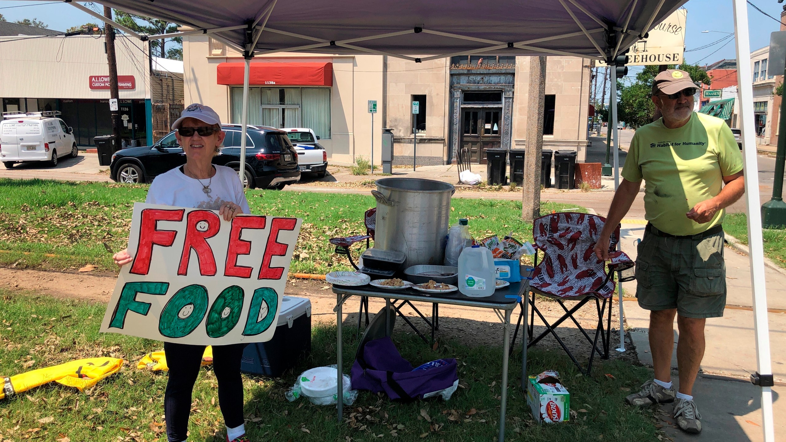 Joyce and Dave Thomas offer free jambalaya, cooked up by one of their neighbors, along the Carrollton streetcar tracks in New Orleans on Thursday, Sept. 2, 2021. Much of the city was without power and many restaurants and individuals were trying to help the community with free food. (AP Photo/Kevin McGill)