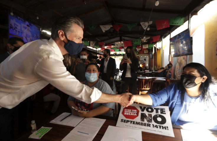 Gov. Gavin Newsom greets volunteers working phone banks in support of voting against the recall on Aug. 14 at Hecho en Mexico restaurant in East Los Angeles.(Genaro Molina / Los Angeles Times)