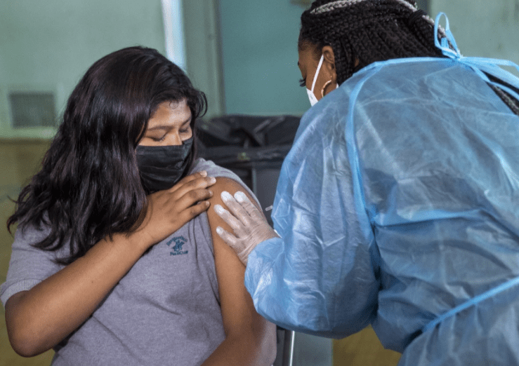 A seventh-grader at San Fernando Middle School receives the first dose of the Pfiizer vaccine inside the school gym on Aug. 30.(Mel Melcon / Los Angeles Times)