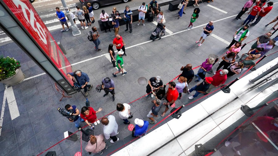 A television crew interviews the first people in line to buy discounted Broadway show tickets at TKTS, Tuesday, Sept. 14, 2021, in New York's Times Square. (AP Photo/Mary Altaffer)