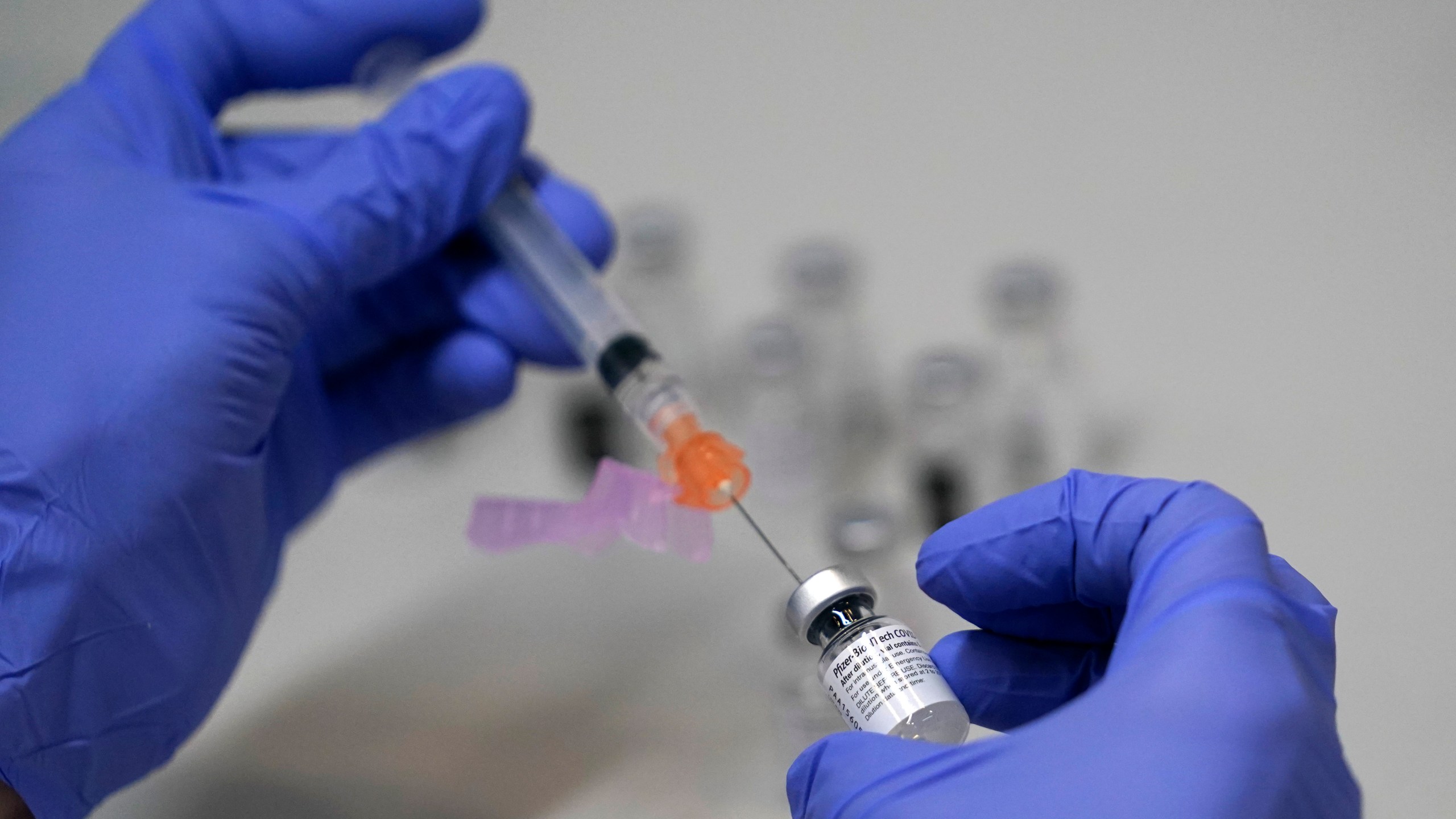 A pharmacy technician loads a syringe with Pfizer's COVID-19 vaccine, Tuesday, March 2, 2021, at a mass vaccination site at the Portland Expo in Portland, Maine. U.S. (AP Photo/Robert F. Bukaty)