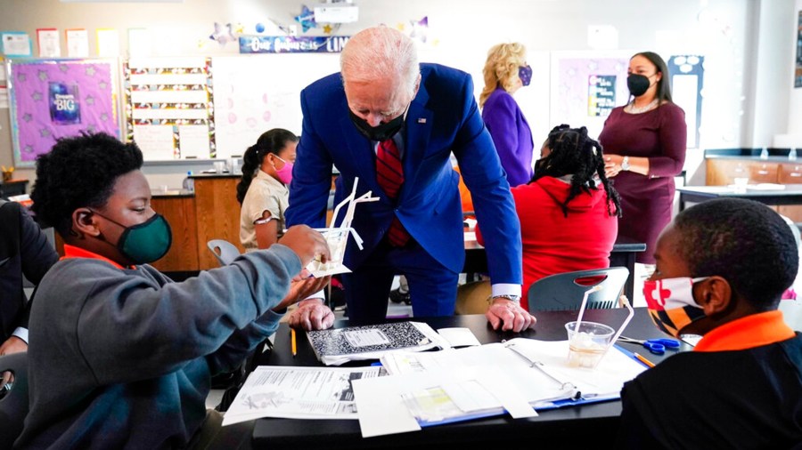 In this Sept. 10, 2021, file photo President Joe Biden talks to students at Brookland Middle School in Washington, as first lady Jill Biden talks with Brookland Middle School science teacher Michelle Taylor, right rear. (AP Photo/Manuel Balce Ceneta, File)