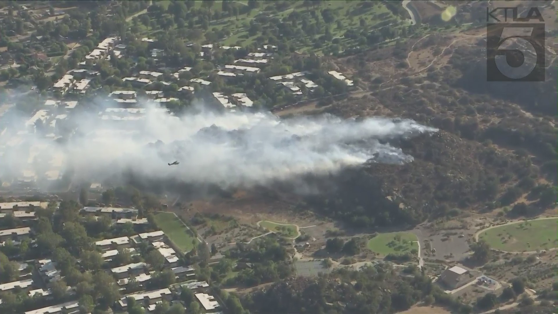 Smoke rises from a hillside in Chatsworth while crews battle a fire on Sept. 22, 2021. (KTLA)