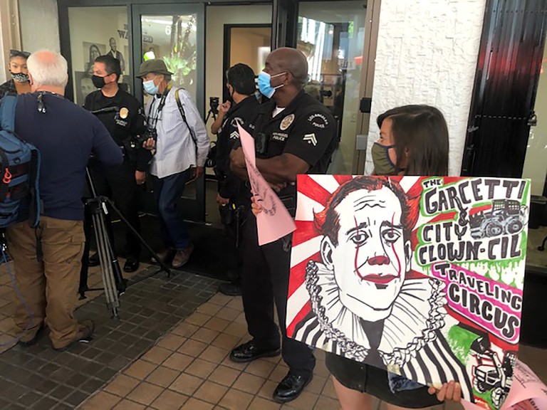 Carla Orendorff, holding a sign targeting Garcetti, protests outside a new department focused on civil rights on Sept. 13, 2021. (Dakota Smith / Los Angeles Times)