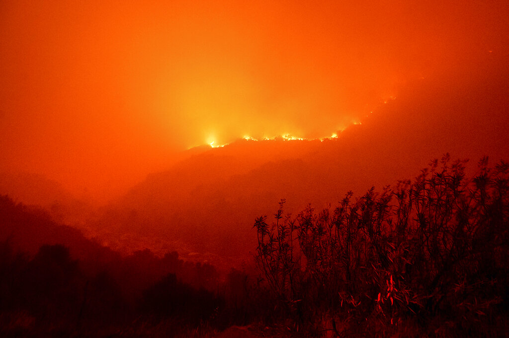 Flames from the KNP Complex Fire burn along a hillside above the Kaweah River in Sequoia National Park, Calif., on Tuesday, Sept. 14, 2021. (AP Photo/Noah Berger)