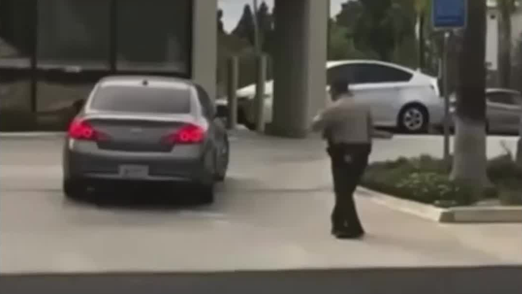 Cellphone video shows an officer shooting at a moving vehicle in Long Beach on Sept. 27, 2021. (Long Beach Local News)