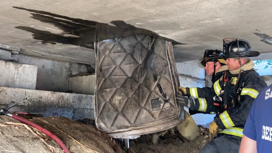 Sacramento firefighters remove a mattress from underneath an overpass on Highway 160. (Sacramento Fire Department)