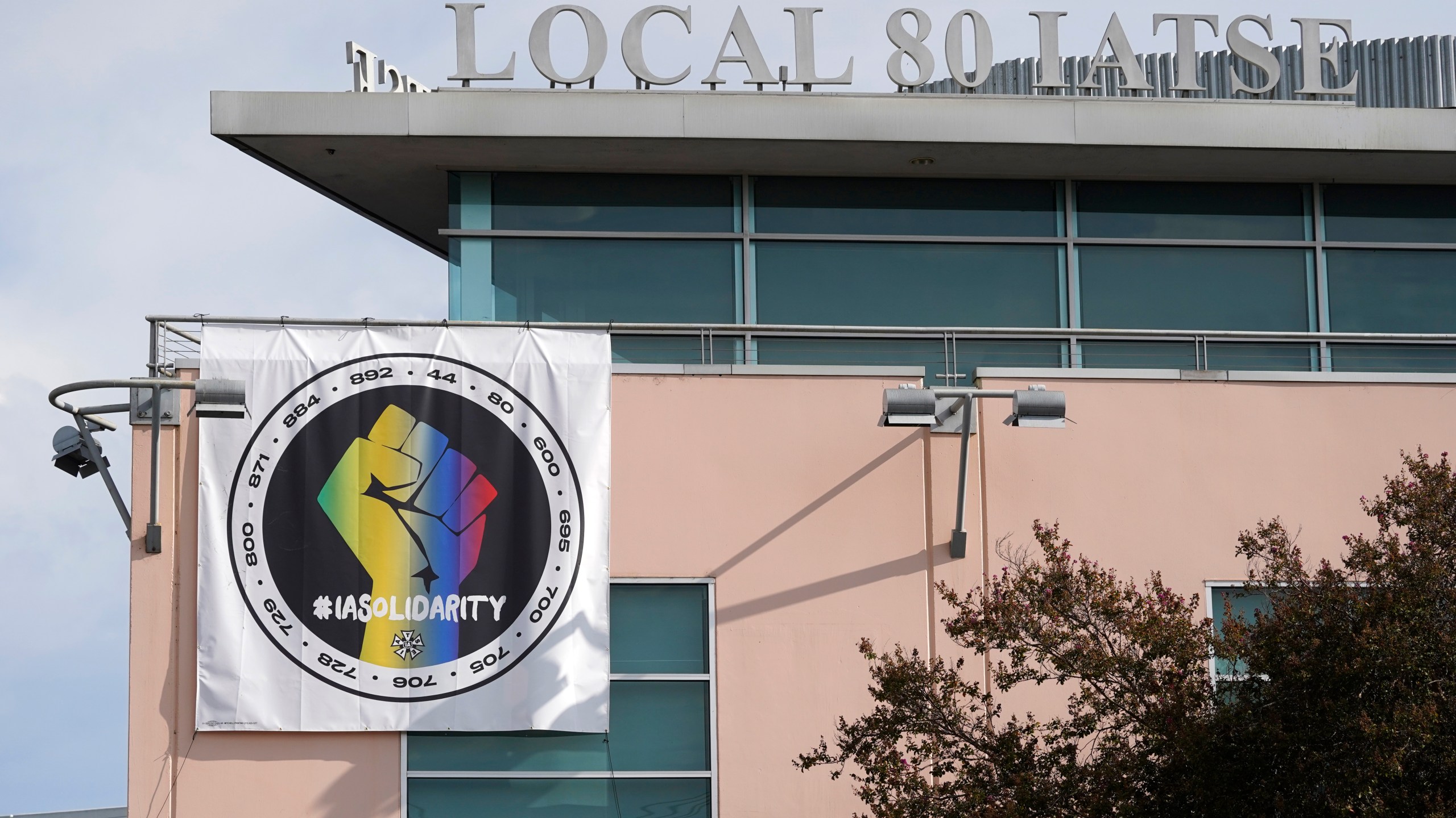 A poster advocating union solidarity hangs from the office building housing The International Alliance of Theatrical Stage Employees Local 80, Monday, Oct. 4, 2021, in Burbank, Calif. The IATSE overwhelmingly voted to authorize a strike for the first time in its 128-year history. (AP Photo/Chris Pizzello)