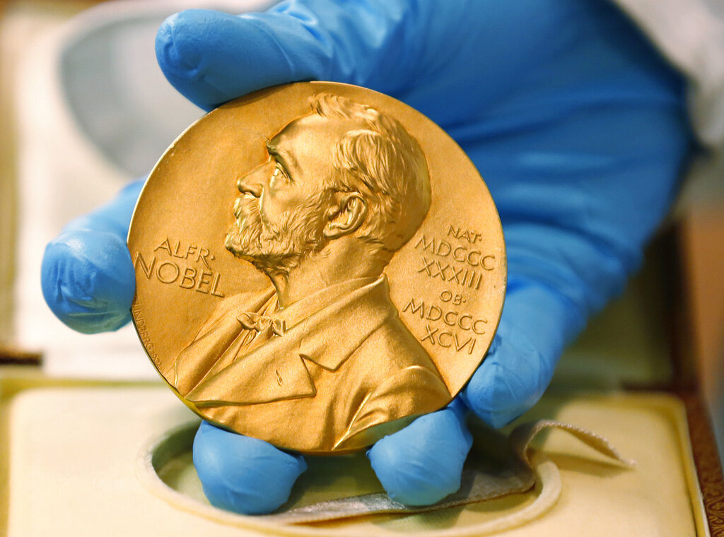 In this file photo dated Friday, April 17, 2015, a national library employee shows the gold Nobel Prize medal. (AP Photo/Fernando Vergara, File)