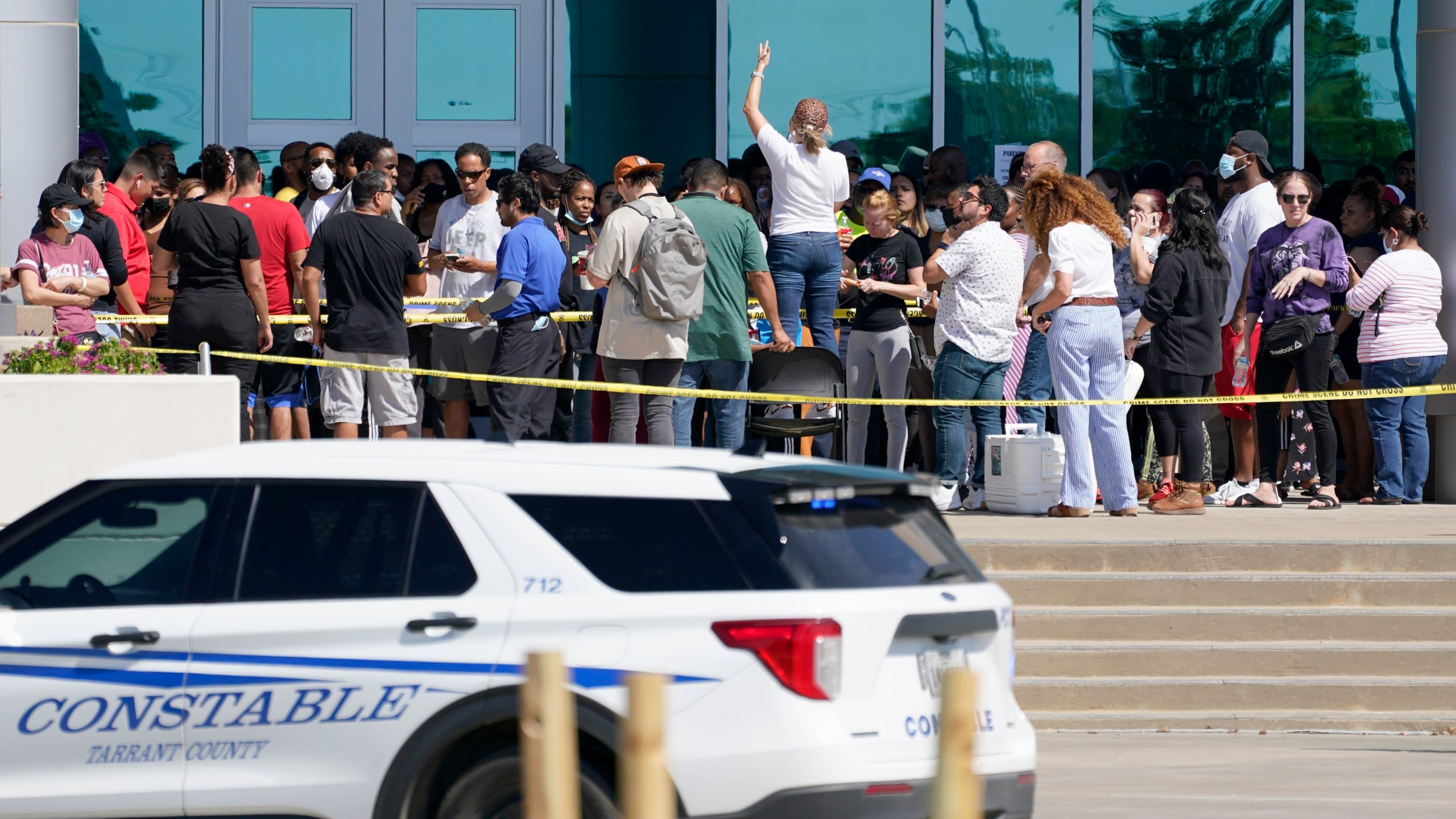 Families are addressed by an unidentified person at center, as they wait to be reunited with their children at the Mansfield ISD Center For The Performing Arts, Wednesday, Oct. 6, 2021, in Mansfield, Texas, following a school shooting at Timberview High School in Arlington. (AP Photo/Tony Gutierrez)